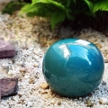 Turkusowa kula ceramiczna szkliwiona w ogrodzie