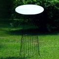Biała lampa LED stojąca na stelażu elipsa Micante Ufo w ogrodzie